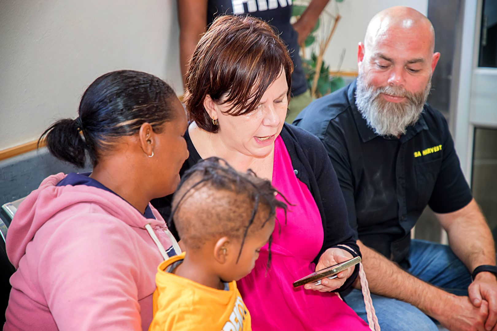 Daily Maverick journalist Estelle Ellis with SA Harvest CEO Ozzy Nel, uploading a mother and baby’s information on the SA Harvest distribution app during a Buckets of Nutrition drop‑off for oncology families in Port Elizabeth, 2024.